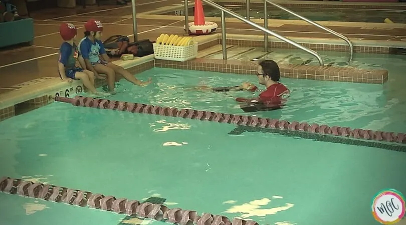 Child doing backstroke for turtle 1 british swim school lesson with instructor.