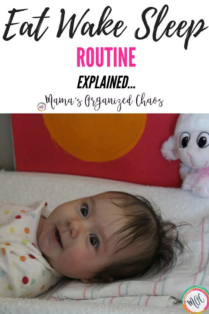 What is the Babywise Eat Wake Sleep Cycle? Baby just woke up from her nap and is on the changing table getting ready to be fed as a part of the eat wake sleep routine. She is smiling and wearing a rainbow polka dot long sleeve onesie.