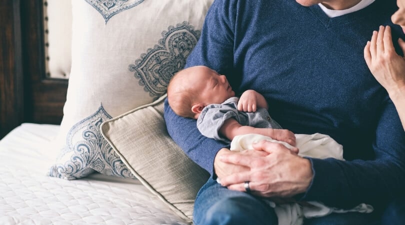 Dad holding newborn baby.