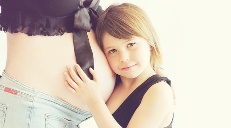 Child hugging pregnant moms belly. Best gifts for second baby.