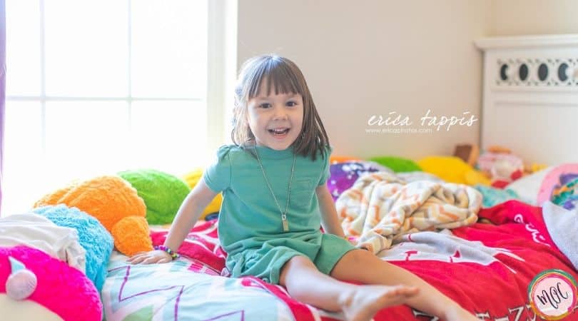 4 year old girl in teal dress smiling